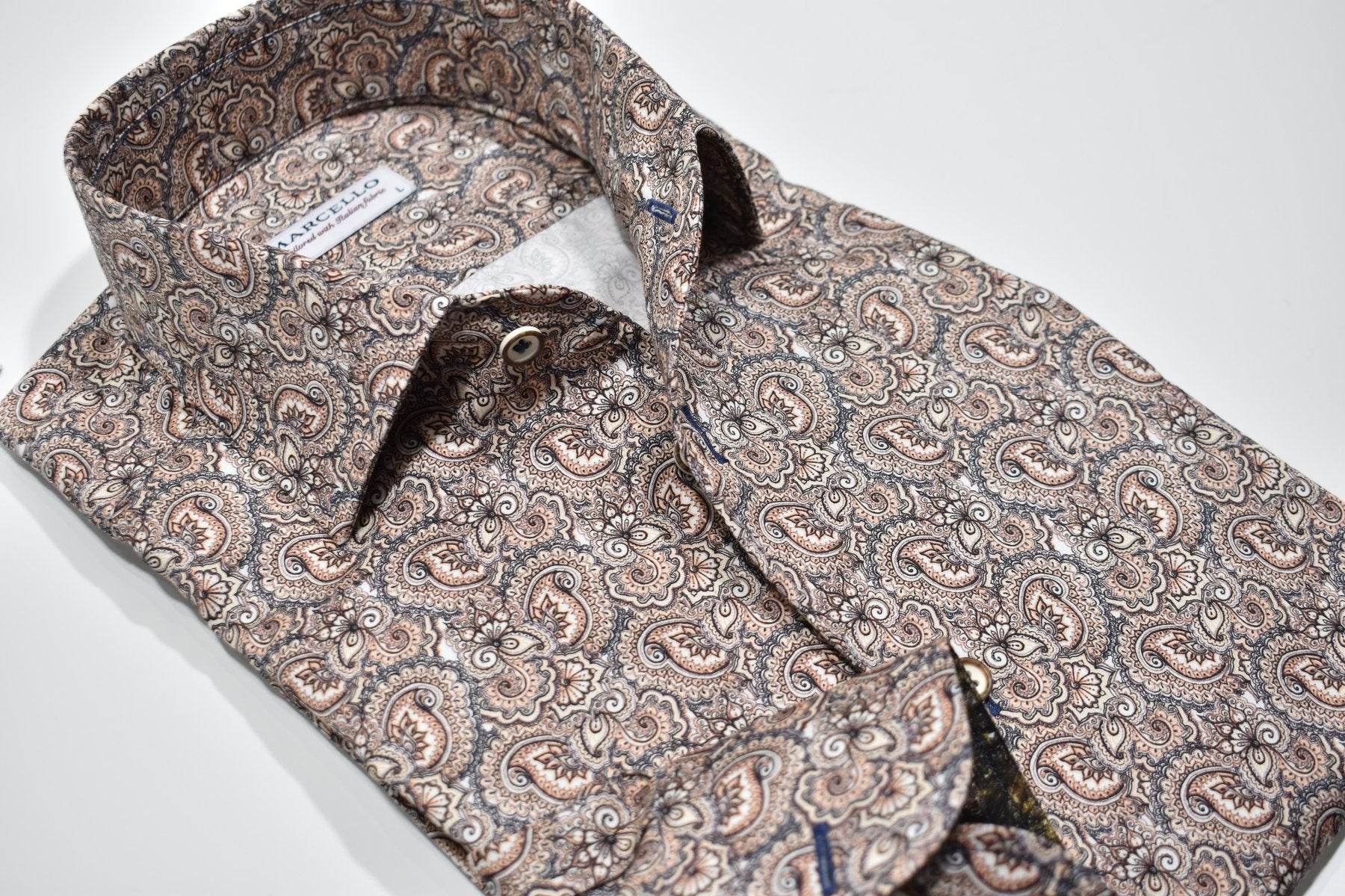 Elevate your style with the Marcello Tan Paisley Roll Collar. Our exclusive one piece roll collar provides a polished look, whether worn alone or under a sport coat. In soft shades of tan, mocha, and gray, this paisley pattern adds a touch of sophistication to any outfit.