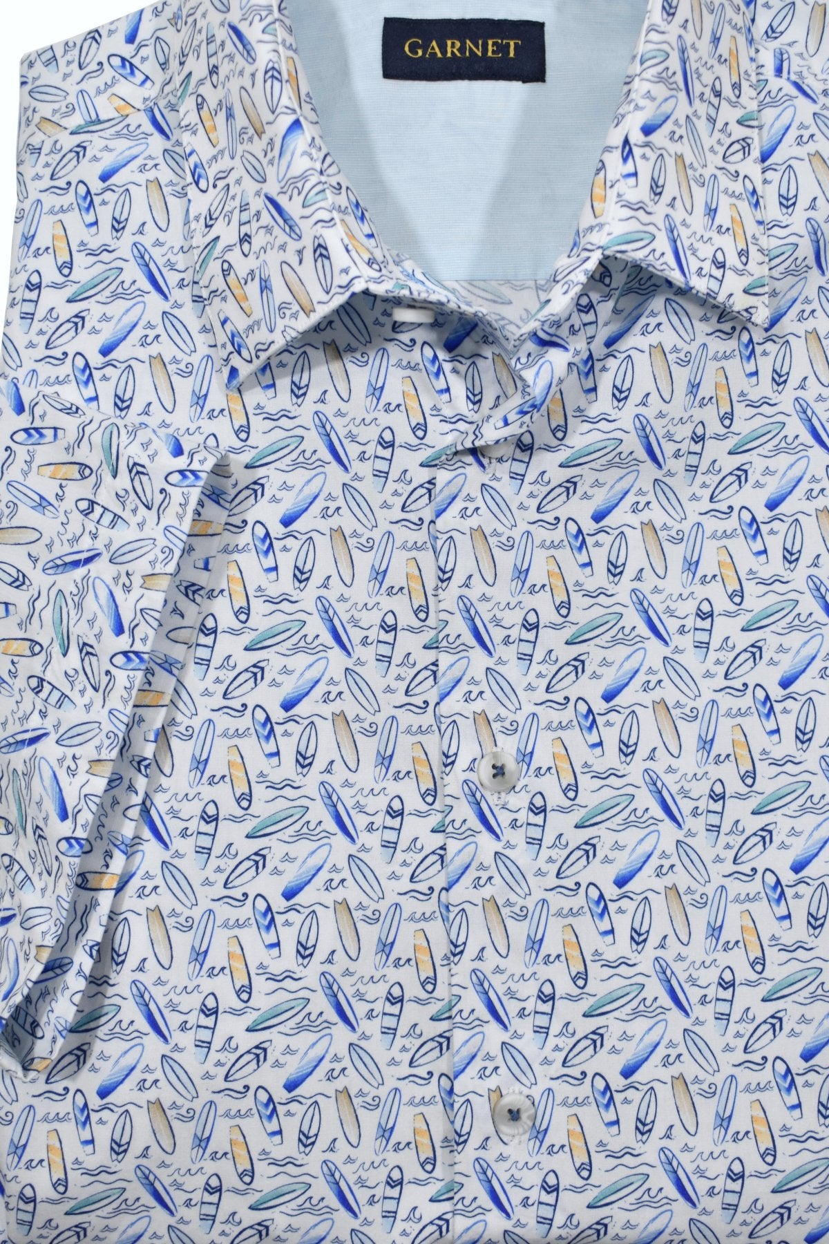 "Ride the wave of style with our ZA10861 Catchin' Waves Shirt! Made from soft cotton sateen, this conversational shirt features a playful print of small surfboards and waves in rich ocean colors. With a tailored collar, trim fabric, and short sleeves, you'll be ready to hit the beach in style.