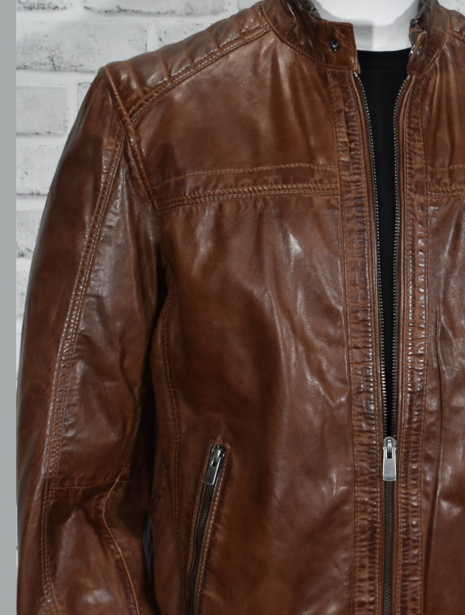 Look smart wearing this tobacco-colored leather bomber jacket. Crafted from soft, washed leather, this classic piece features cool stand-up baseball-style collar, cross-stitch shoulder detailing and open sleeves and bottom for a timeless look. Soft-lined with classic pockets, this bomber jacket offers a classic fit and feel.