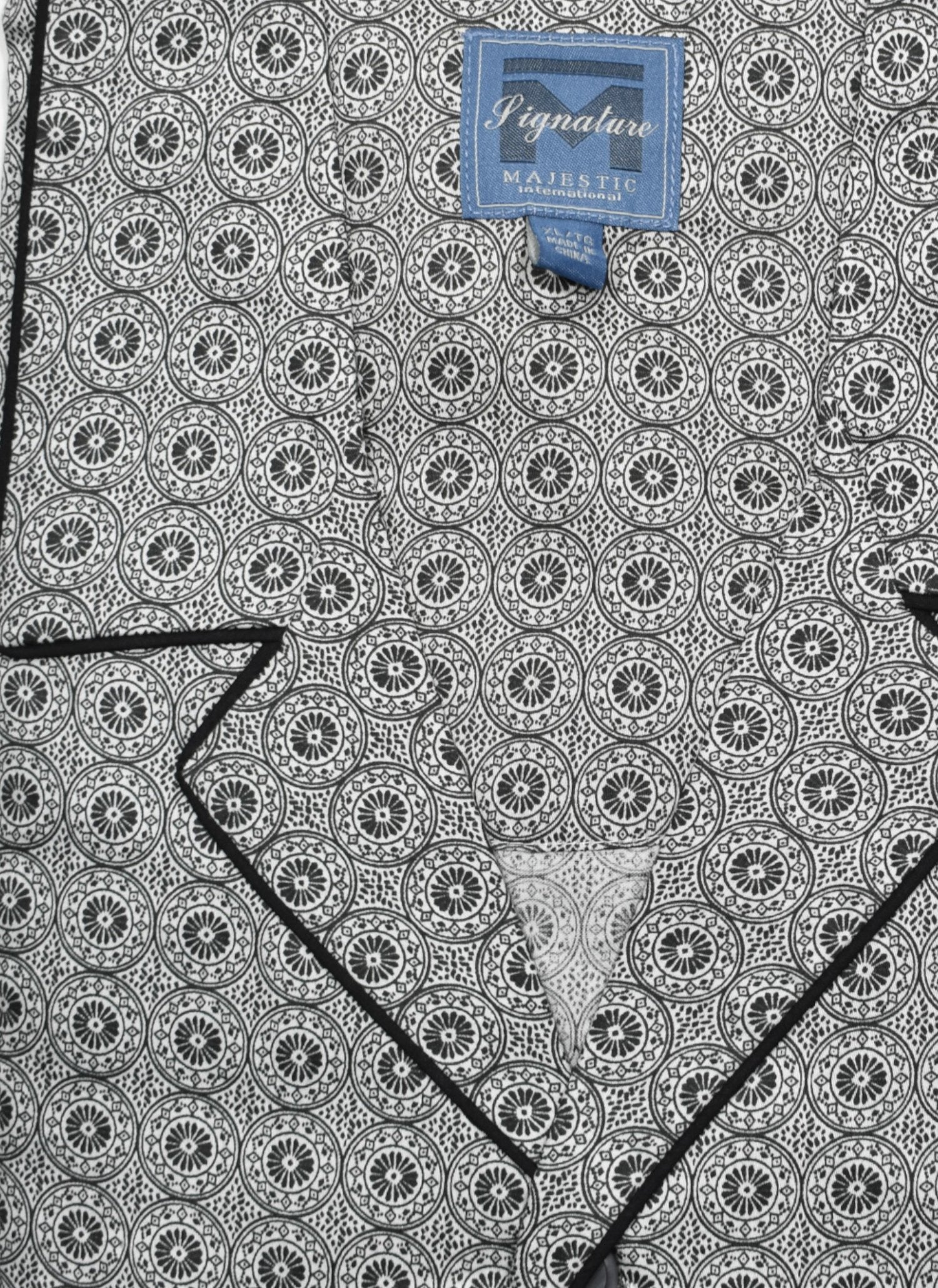 Indulge in luxurious comfort with the ZMJ9190 Slate Medallion Pajama. Made with soft cotton and featuring a circular medallion pattern, this classic pajama set offers a relaxed fit and added style with contrast black piping and a drawstring waist. The perfect choice for a good night's sleep.