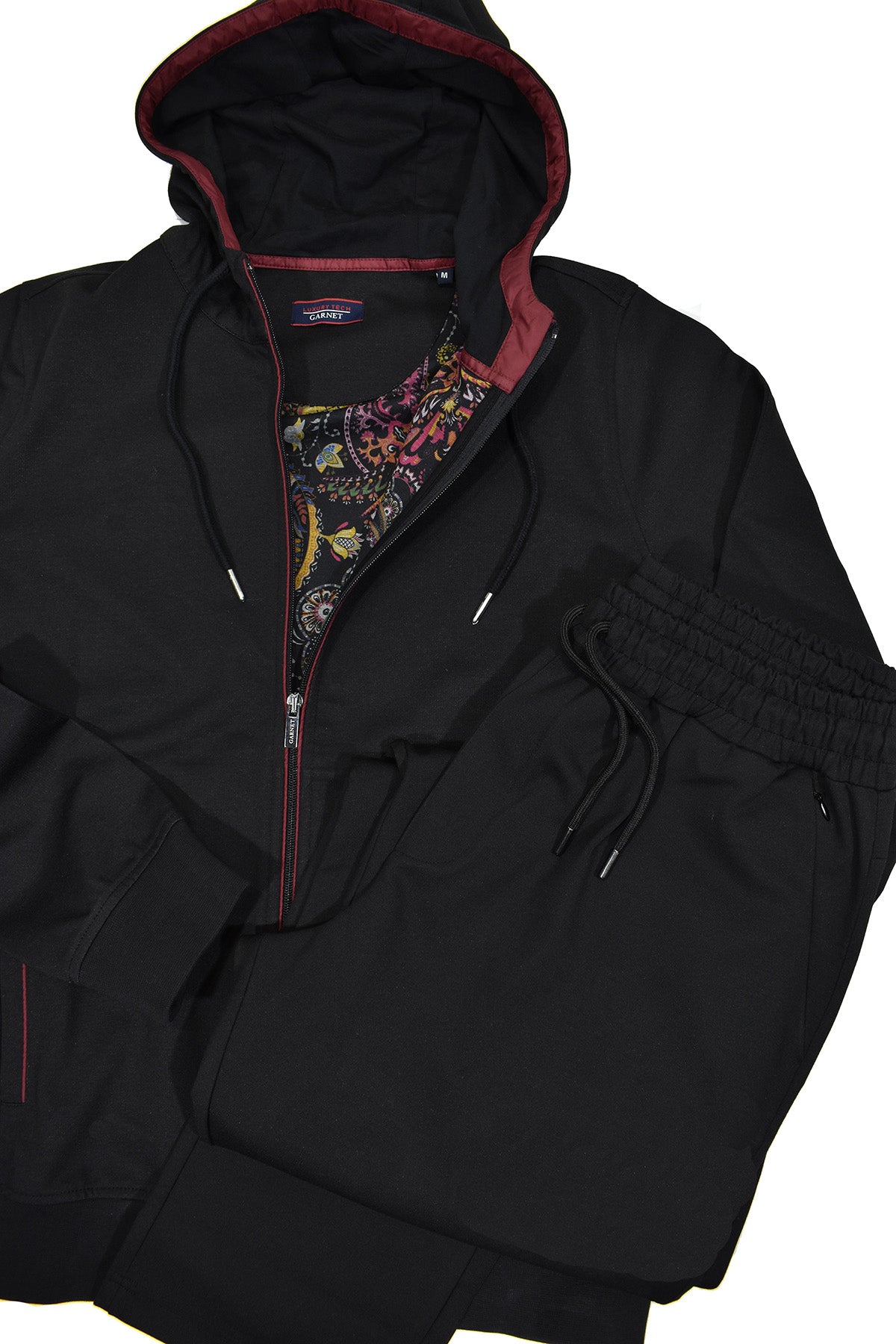 The ultimate in leisure set style, this black set features a soft cotton microfiber fabric with a contemporary hoodie style top.  Side slash pockets on the jacket and pant have an extra fine zipper closure and both the pant and jacket have draw string functionality.    Jacket sports a fashion lining for added style.  Pant has a full stretch waist band and classic pockets, all with fine zipper closure.  Open bottom pants, non functioning fly.  Modern fit, perfect for a medium to slim build.