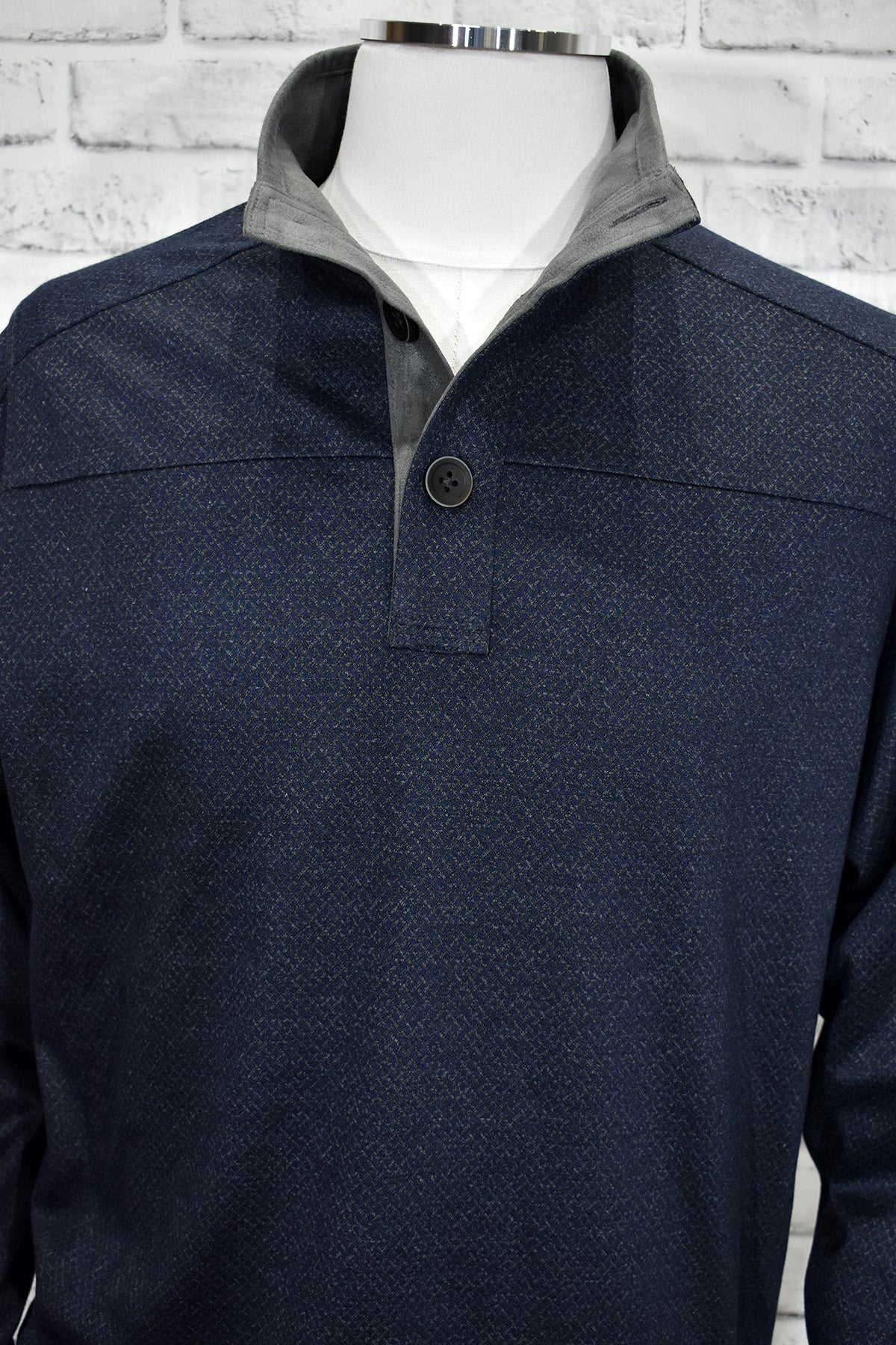 A classic mock neck in cotton microfiber fabric with a fine diamond pattern in soft gray over a navy ground. The performance fabric is great for any event and traveling. Add style to this basic mock with suede trim in the neck and along the button placket. Open sleeves and open bottom for a cool contemporary style. Light weight. Classic fit.