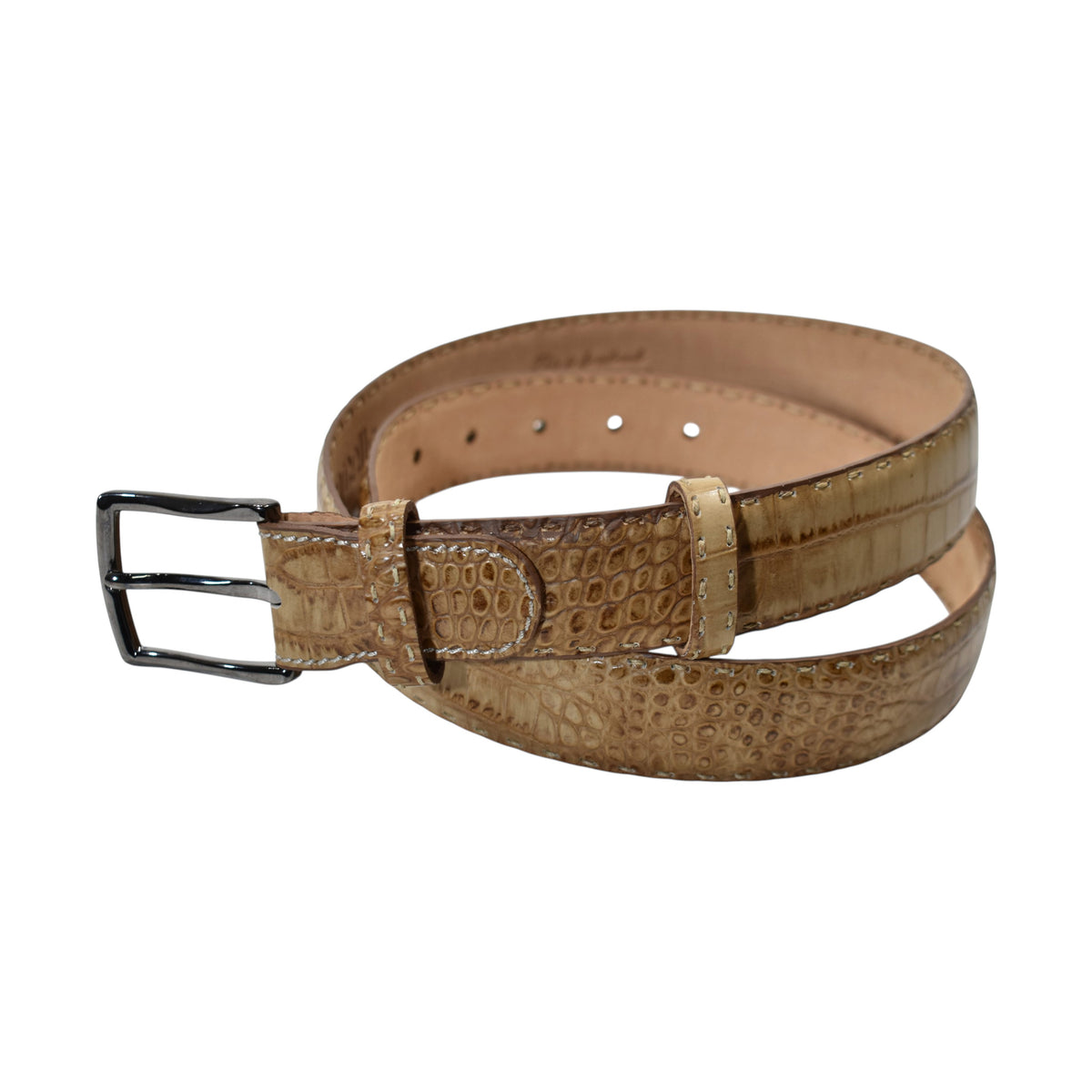A Marcello tan leather belt with a crocodile-embossed texture and a silver-tone metal buckle, coiled on a plain white background.