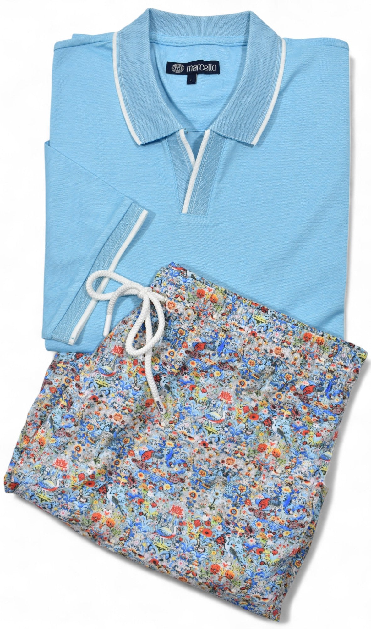 Light blue polo shirt and floral shorts set on a white background by Marcello