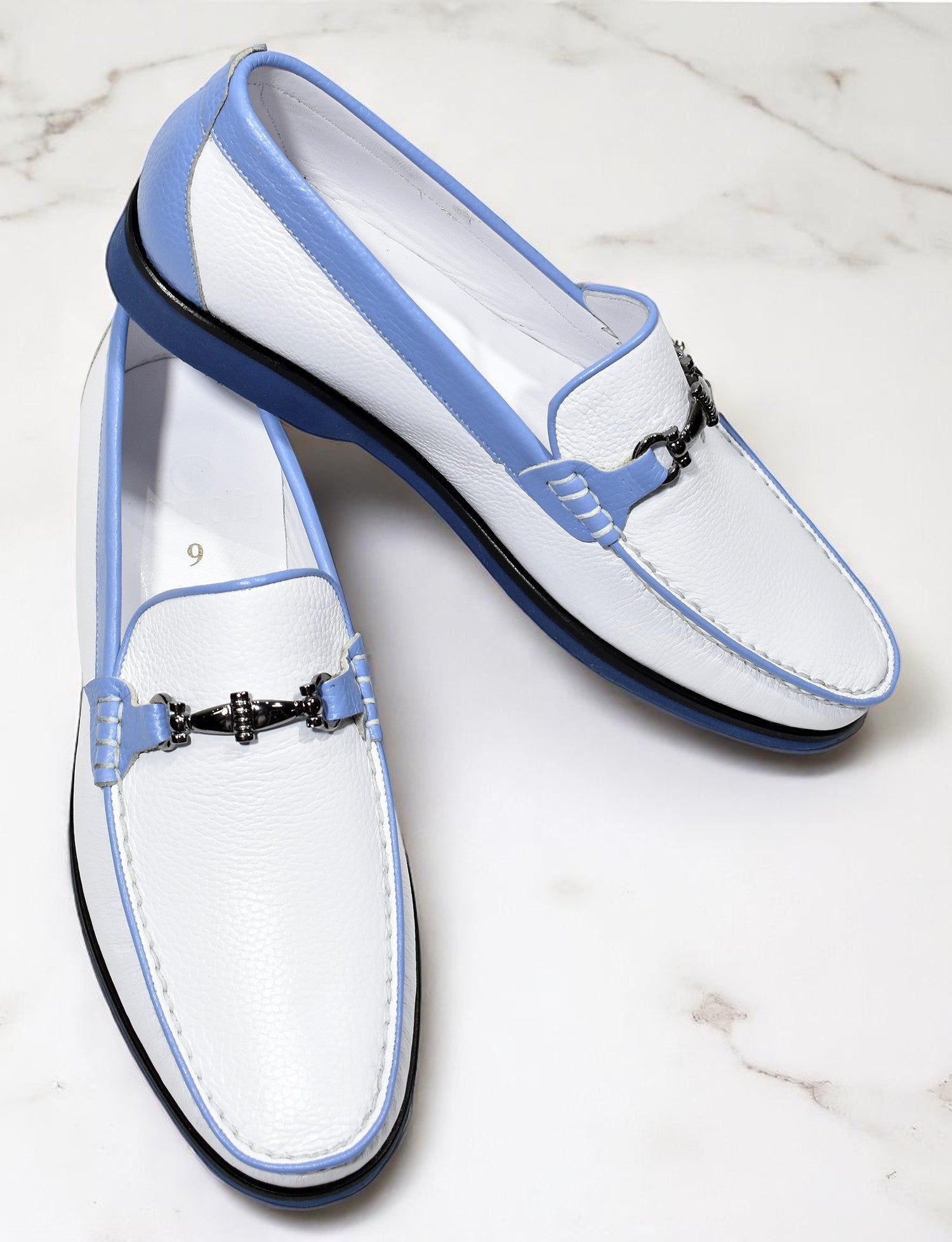 Elevate your casual style with these stunning white leather loafers featuring sophisticated blue trim.