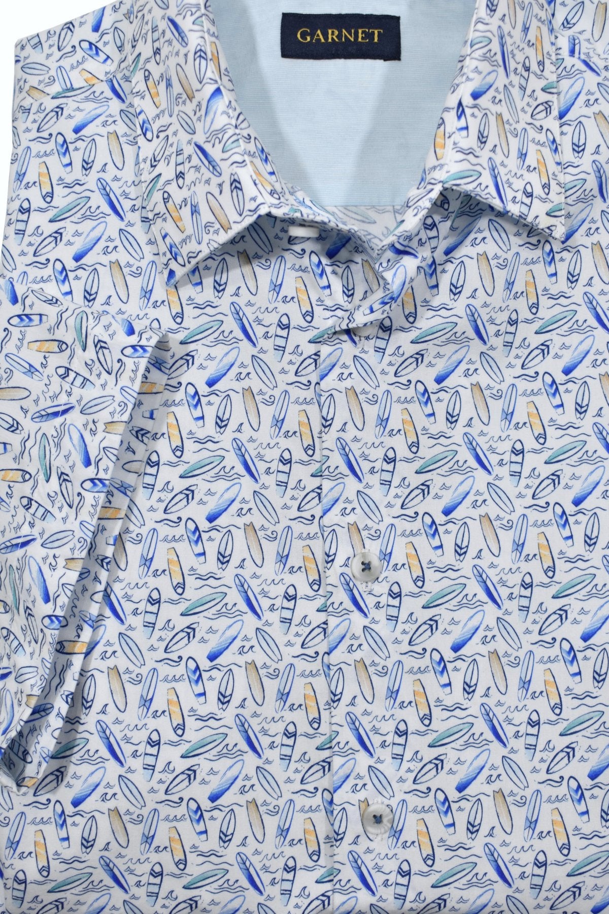 "Ride the wave of style with our ZA10861 Catchin' Waves Shirt! Made from soft cotton sateen, this conversational shirt features a playful print of small surfboards and waves in rich ocean colors. With a tailored collar, trim fabric, and short sleeves, you'll be ready to hit the beach in style. 