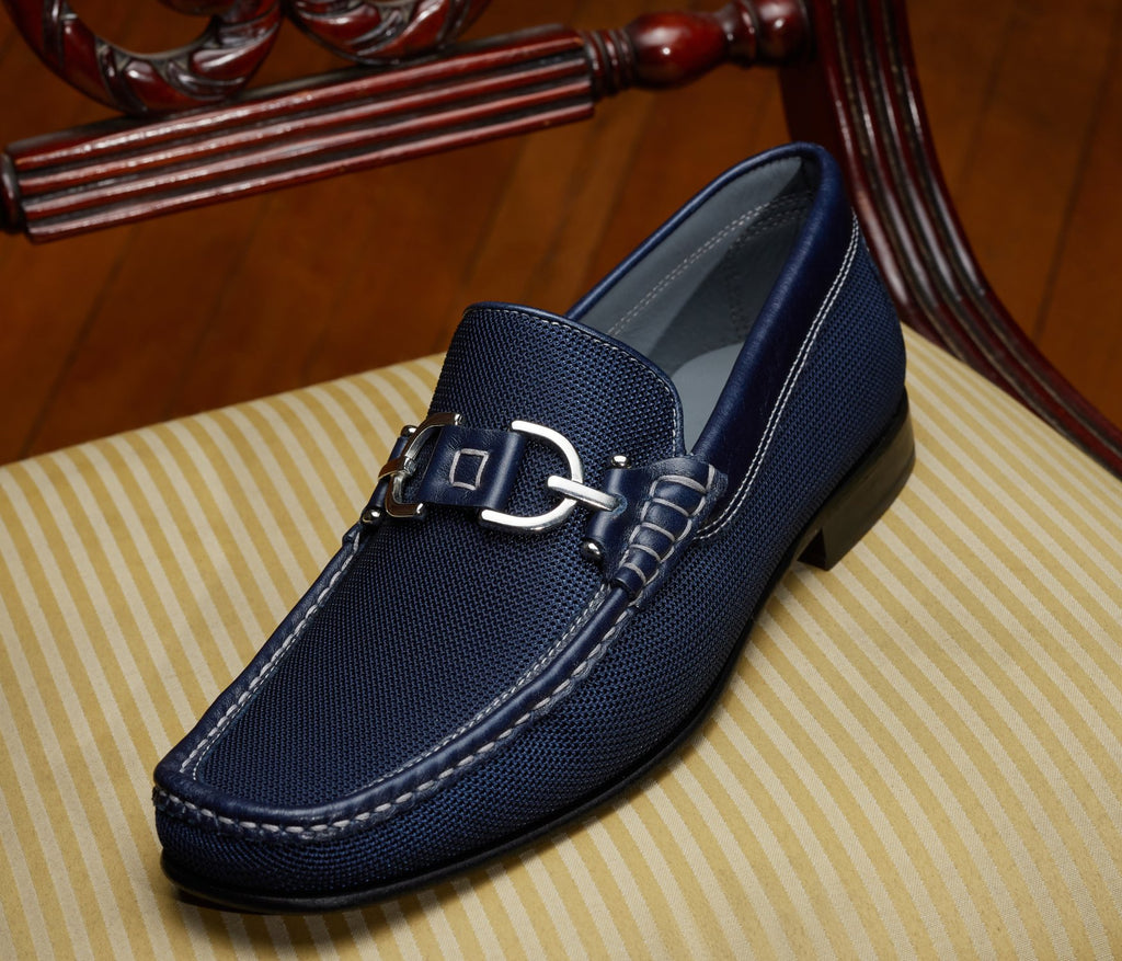 Make a statement with the Navy Italian Dacio. This classic Donald Pliner shoe oozes style and fashion with its textured canvas outer in a true navy cross stitch, leather trim, signature Pliner hardware, and a leather sole. Its true navy color with matching navy trim will lend a sophisticated touch to any outfit.