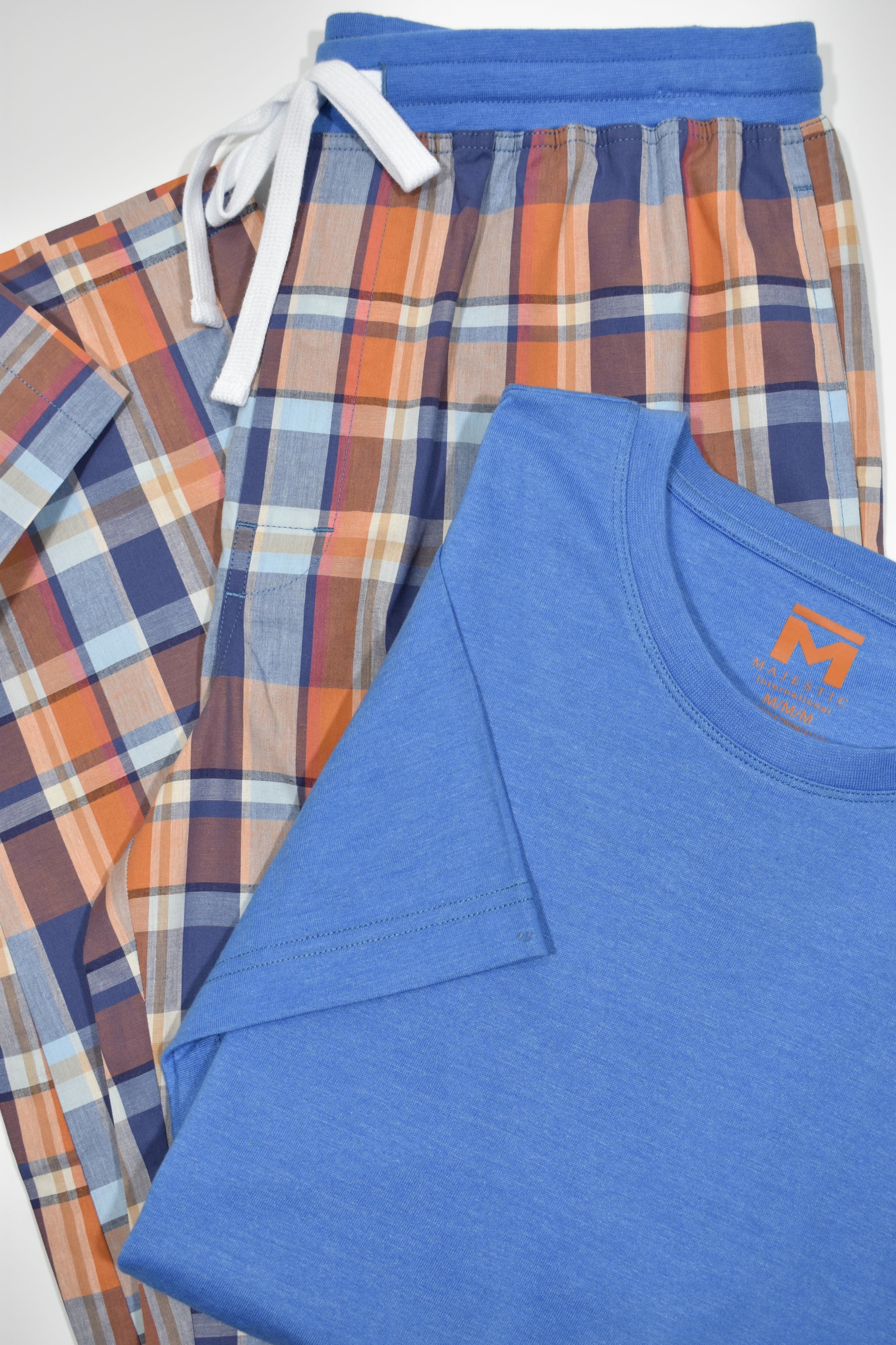 The Cavalier and Florida ZM21180 Leisure Set is perfect for Spring/Summer. Crafted from lightweight cotton, the drawstring pants feature a traditional plaid design in vibrant shades of orange and blue. Paired with a soft, royal blue Pima tee, this set offers both comfort and style. Perfect for relaxation and leisure time.