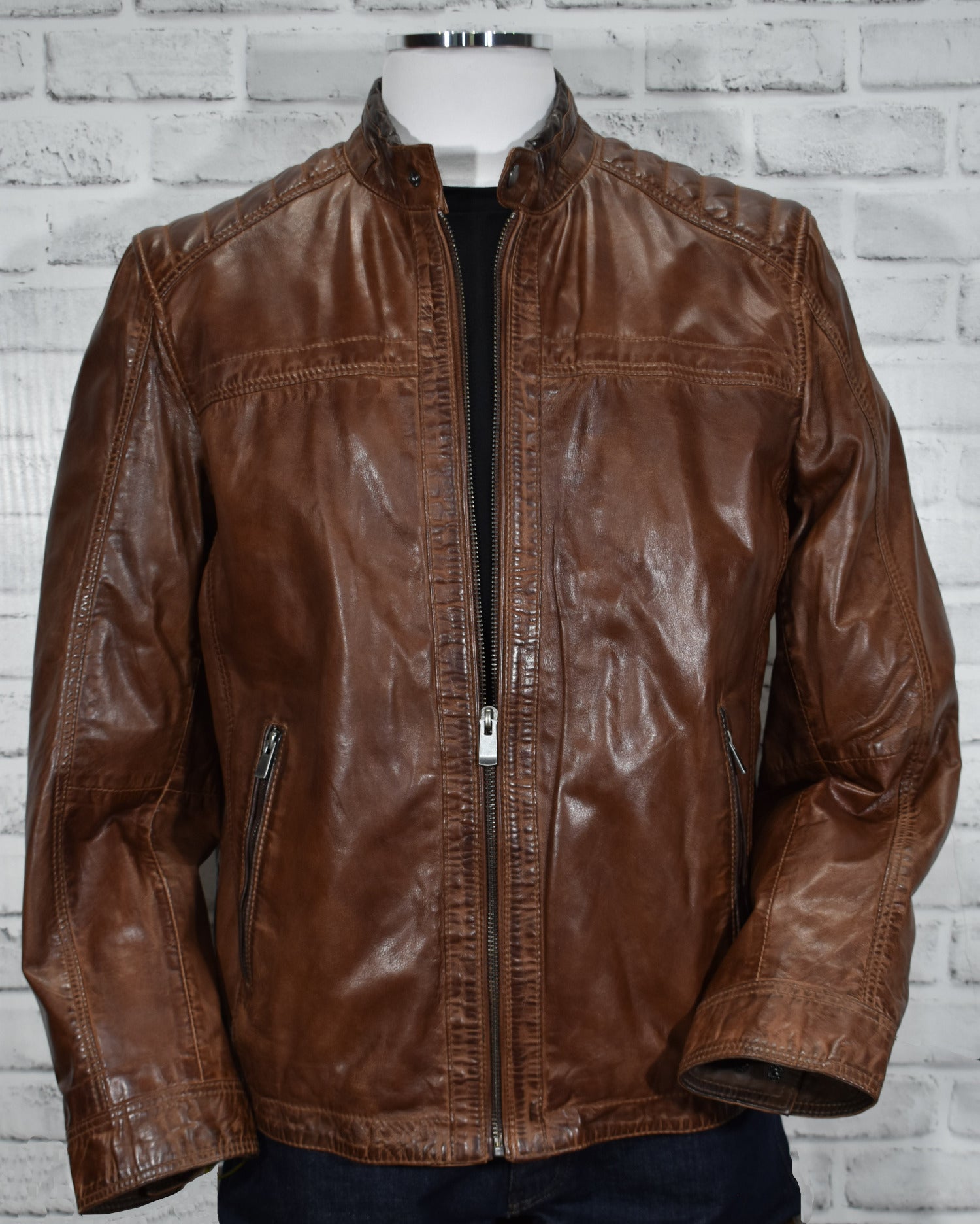 Look smart wearing this tobacco-colored leather bomber jacket. Crafted from soft, washed leather, this classic piece features cool stand-up baseball-style collar, cross-stitch shoulder detailing and open sleeves and bottom for a timeless look. Soft-lined with classic pockets, this bomber jacket offers a classic fit and feel.