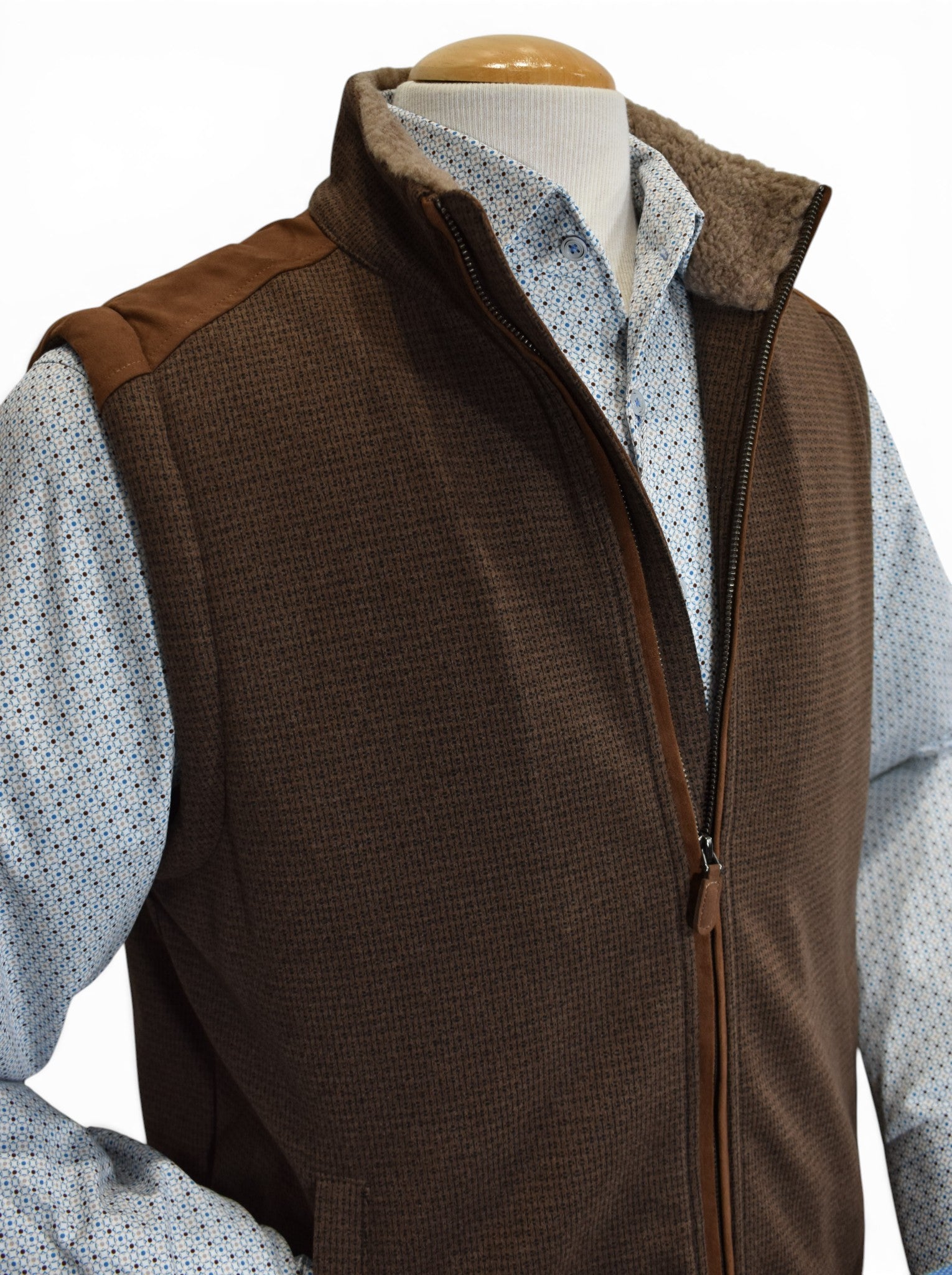 Perfect for the season, this vest features a faux leather outer with a fine subtle box print pattern and soft fur lining to add warmth and style. The vest features a stand up collar, two way zipper and ultra suede trim on the shoulders and along the zipper. Classic fit.