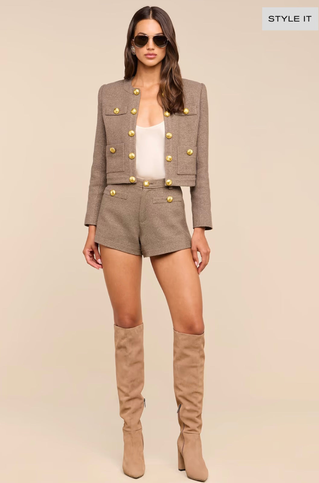 Woman wearing a tailored jacket, shorts and tall boots
