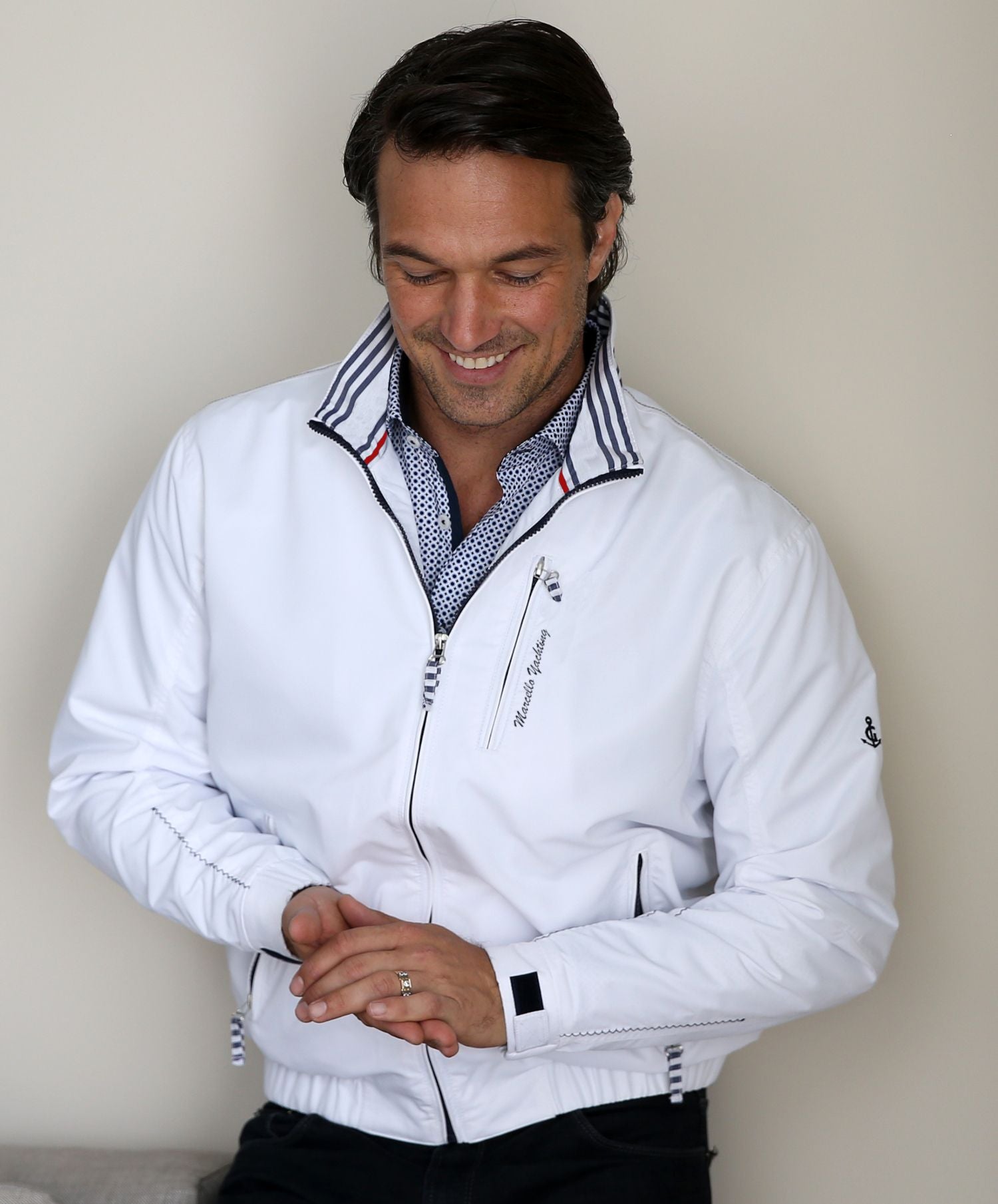 Following up on our exclusive Navigare bomber, the soft microfiber fabric with nautical detailing in contrast navy colors is uniquely cool.  Synthetic microfiber is lightweight, soft and durable. The white color gives the jacket a clean crisp look with a maritime vibe.  Stretch waist for comfort, velcro closure cuffs and a standup collar with contrast color detailing. Marcello White Nautical Jacket