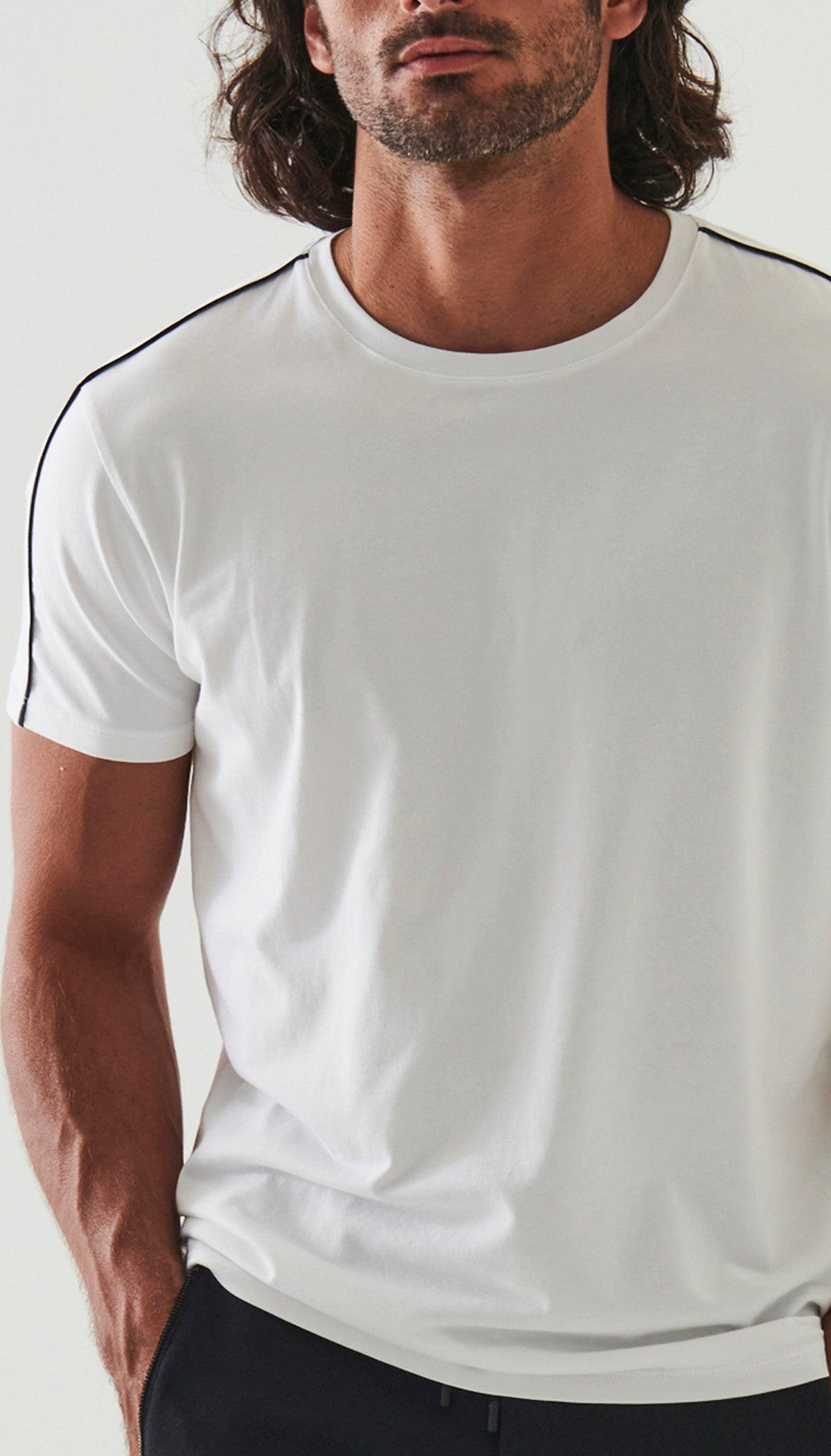 The ultimate in comfort and softness, this ultra soft pima cotton tee sports a fine contemporary style.  Crisp white with a raised black accent along the shoulders and down the sleeve. Soft pima cotton. Designed by Assaraf Italy. Classic tee shirt model Open sleeves and bottom. Modern fit, perfect for a slim to medium build.